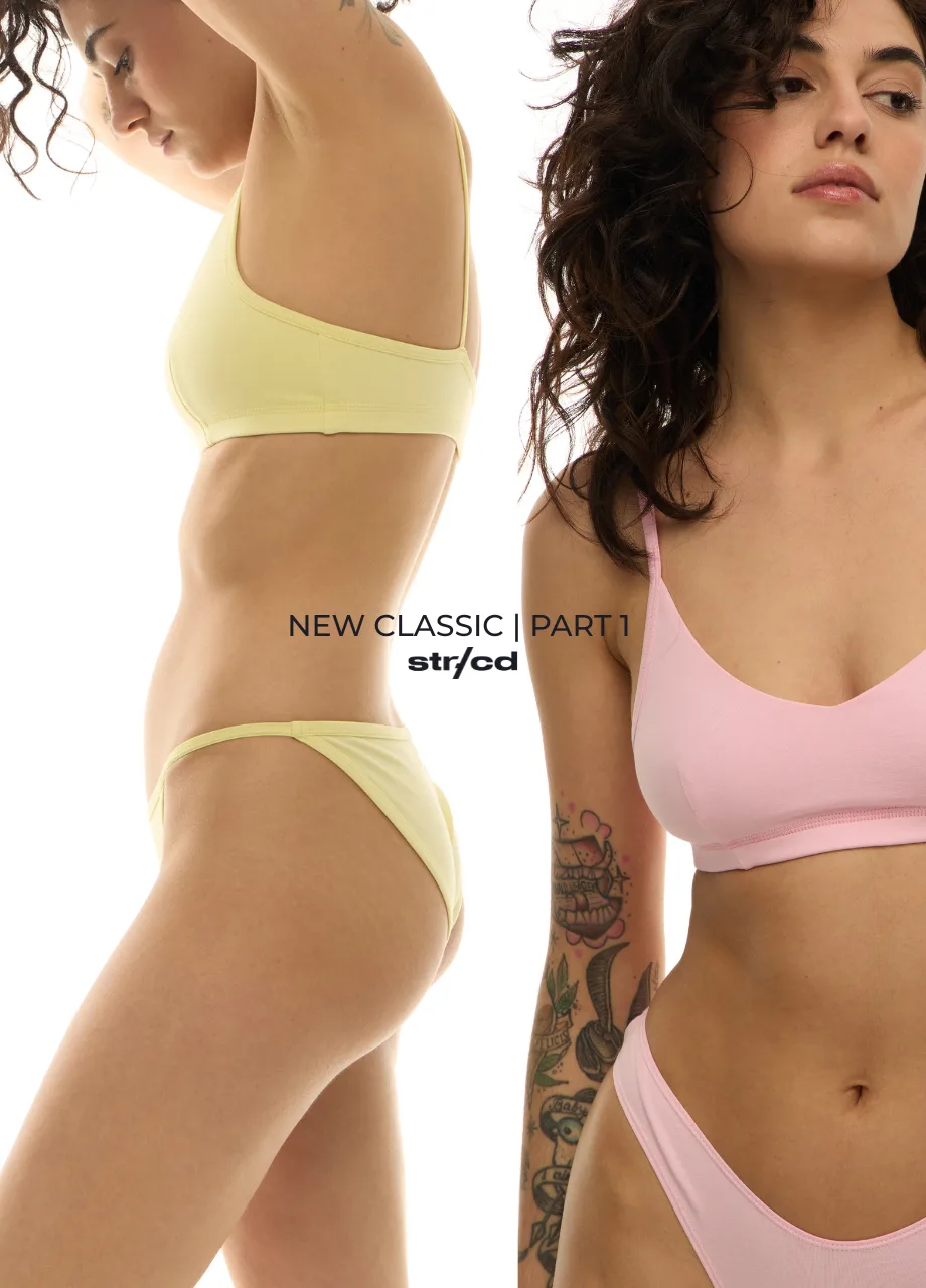 Two models wear pastel lingerie: yellow set on the left and pink set on the right, with a tattooed arm visible, and the text ’NEW CLASSIC | PART 1’ across the center.