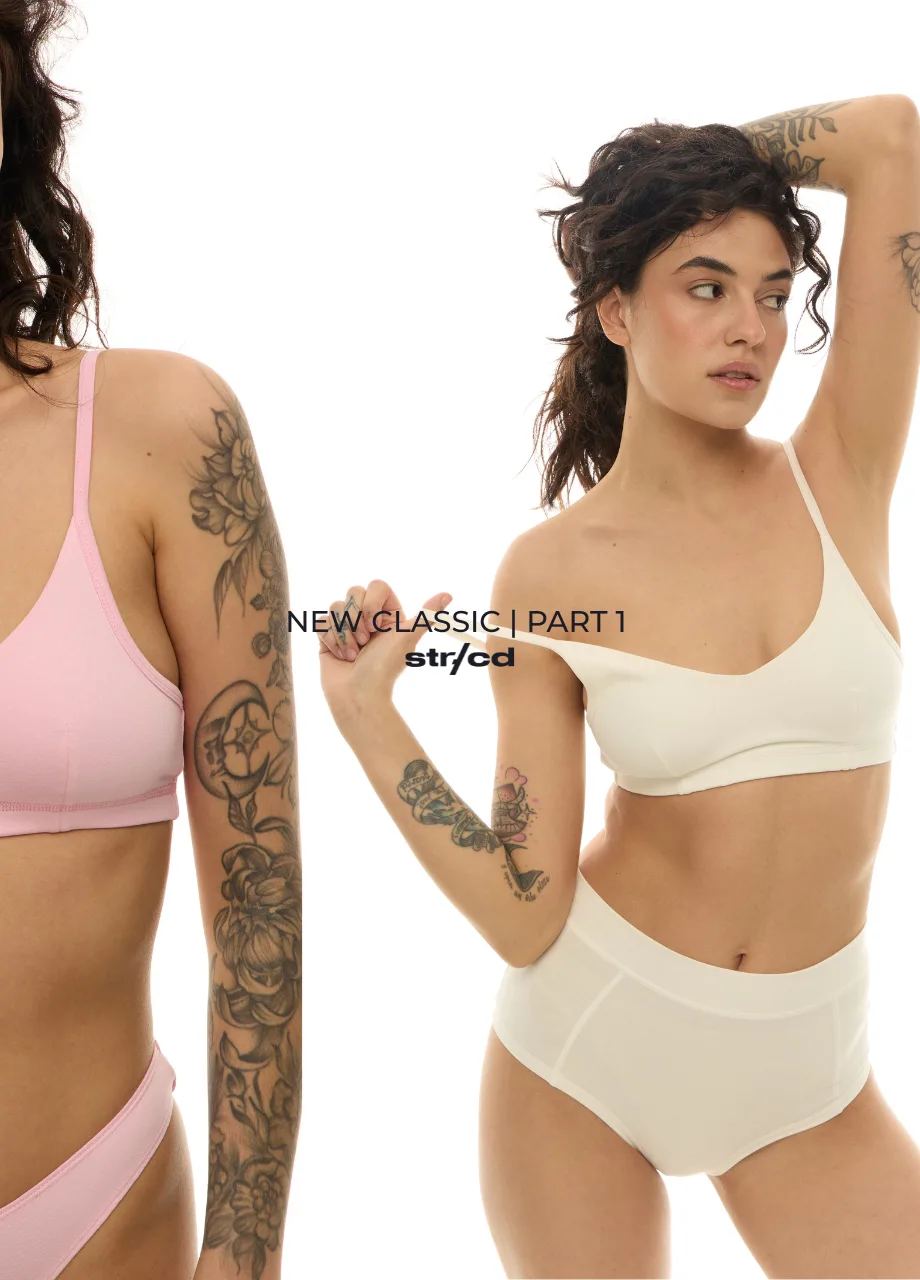 Two women wearing pastel underwear against a white background; centered text reads 'NEW CLASSIC | PART 1' with visible tattoos on their arms and shoulders.