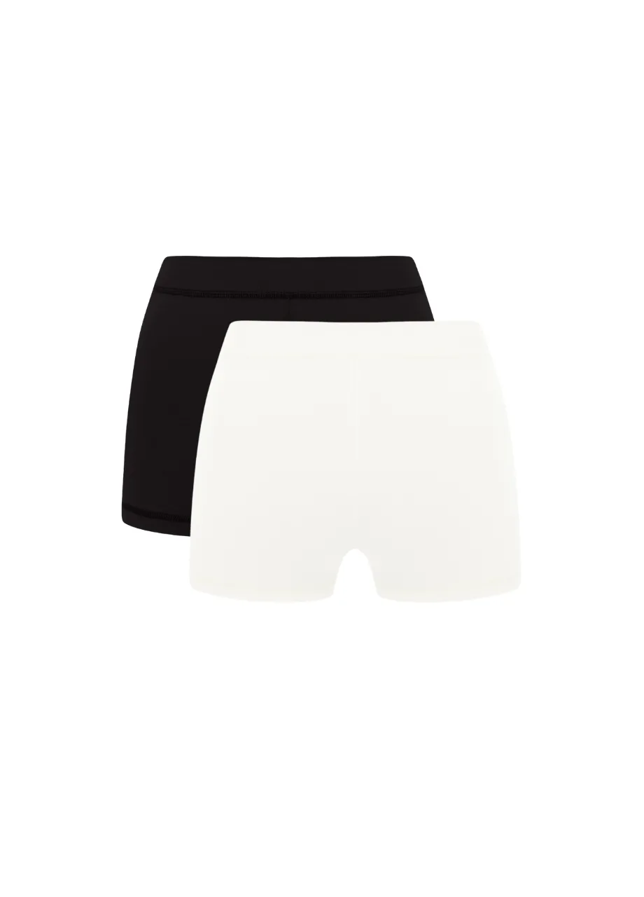9 › Str/Cd Wear Two pairs of seamless women's shorts, black and white, stacked with the white pair in front.