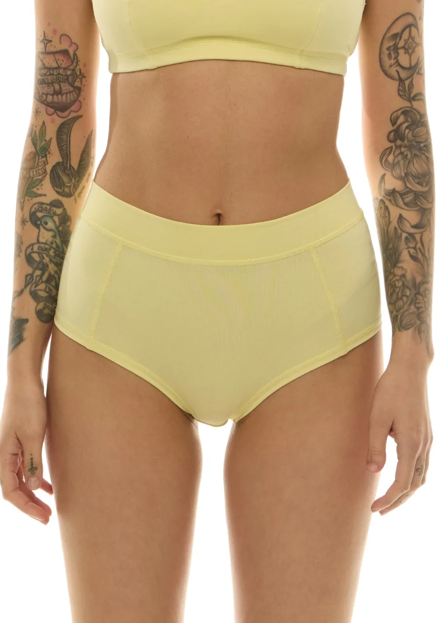 WP611220 › Str/Cd Wear Model wearing pale yellow high-waisted underwear and matching sports bra; torso shot focusing on the midsection.