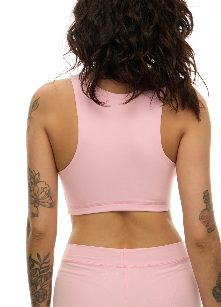 WS509511 › Str/Cd Wear Back view of a person in a pale pink sports bra and matching leggings, showing tattoos on both arms.