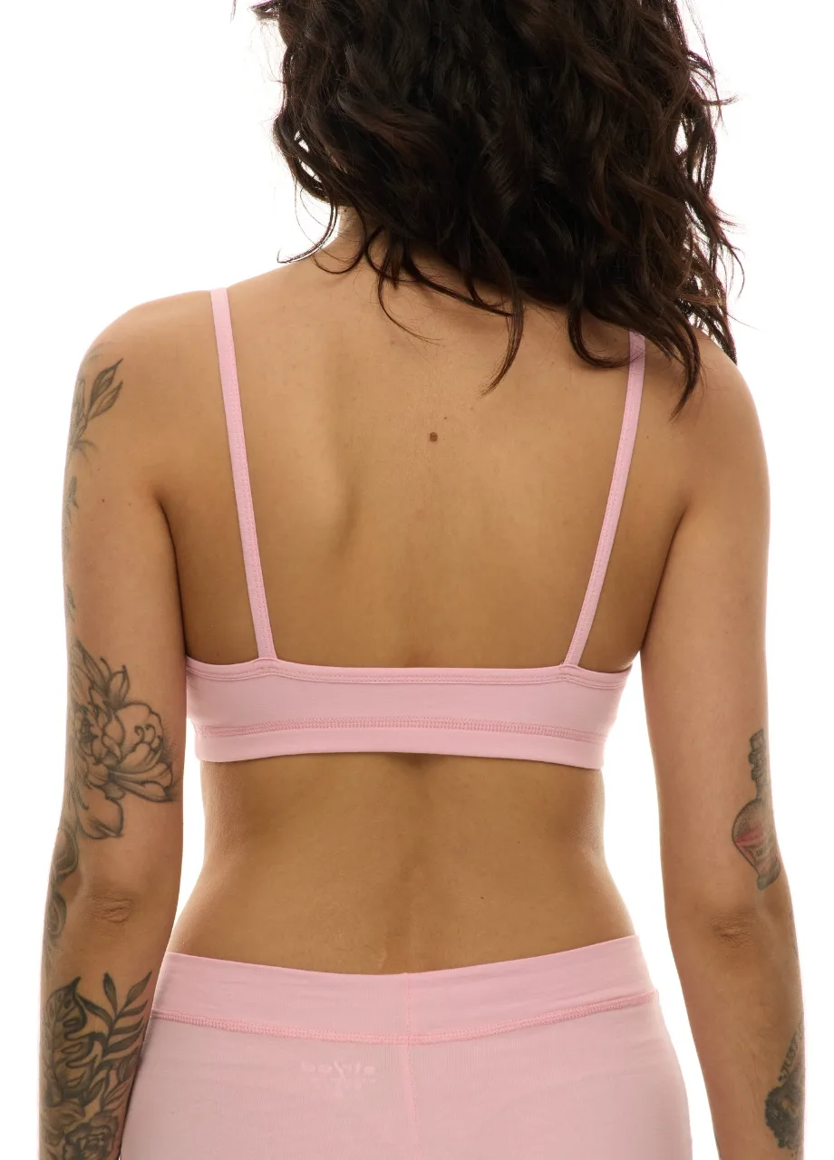 WS511110 › Str/Cd Wear Woman seen from behind wearing a light pink bra and matching high-waisted underwear; visible tattoos on both arms.