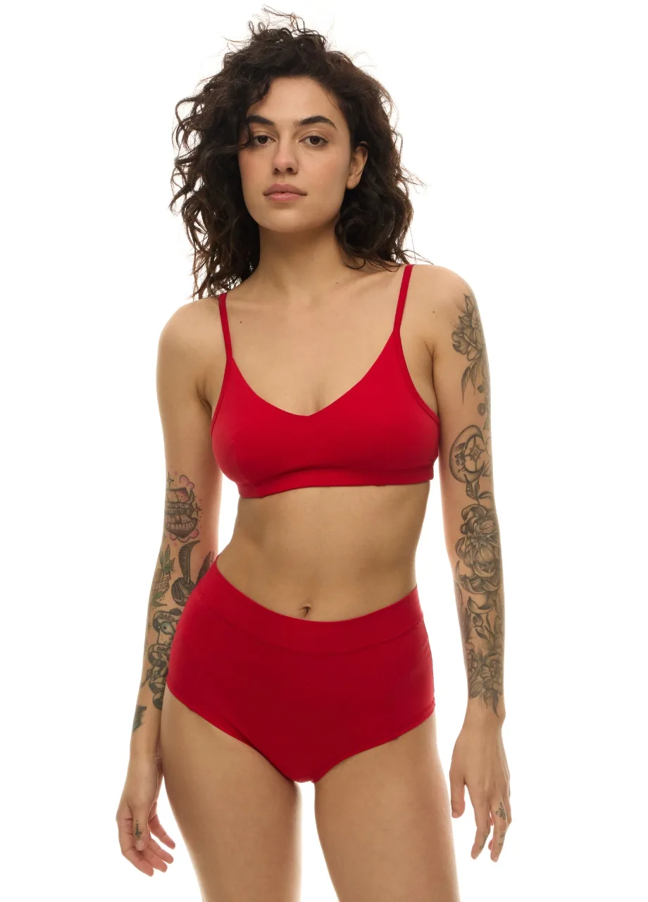 WS511115 › Str/Cd Wear Woman wearing a red bikini set (triangle top and high-waisted bottoms) with tattoos on both arms against a white background.