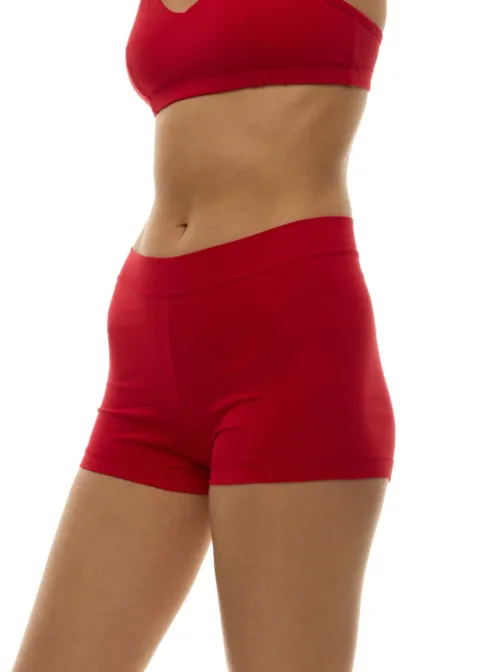 Model wearing a red athletic bra and matching red shorts, showing a slim midsection against a white background.
