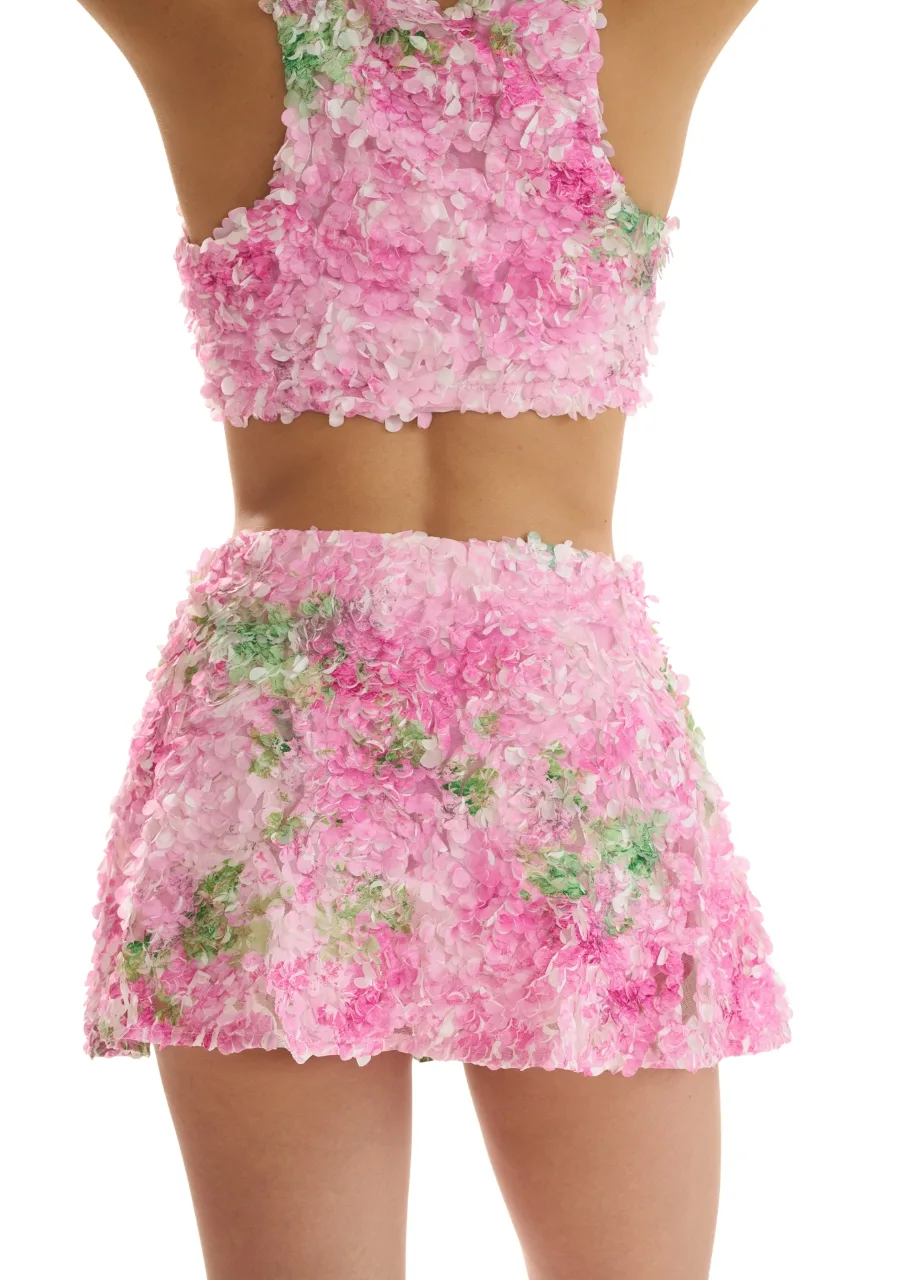 2 › Str/Cd Wear Back view of a person wearing a pink floral textured crop top and matching mini skirt.