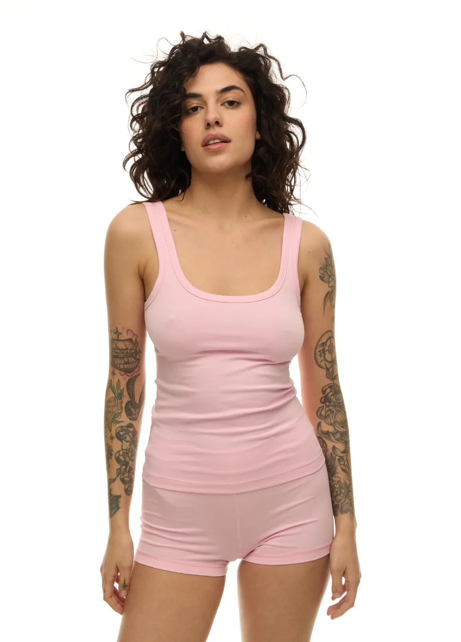 60 › Str/Cd Wear Woman wearing a light pink tank top and matching shorts, standing against a white background.