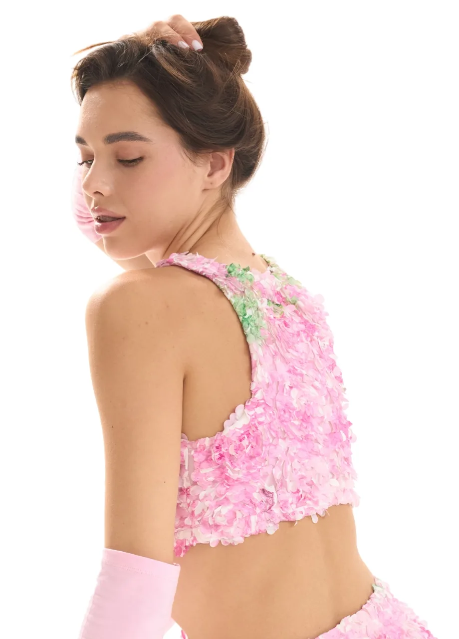 WS5095 website копія 3 › Str/Cd Wear Woman seen from behind wearing a pink, flower-textured crop top with a matching skirt; hair in an updo, head slightly turned downward.